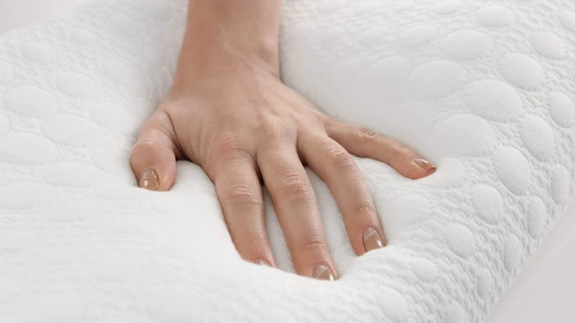 Die Hand einer Frau drückt auf eine Memory-Foam-Matratze