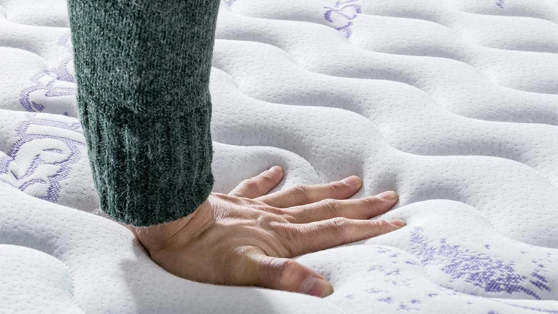 das Bild einer Hand, die die oberste Schicht der Vesgantti Lavendel Matratze drückt